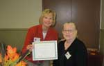 Immediate past-president, Coleen Landry, presents a certificate to Ann Riser acknowledging her 25 years as a member of Metairie Woman's Club.  2010